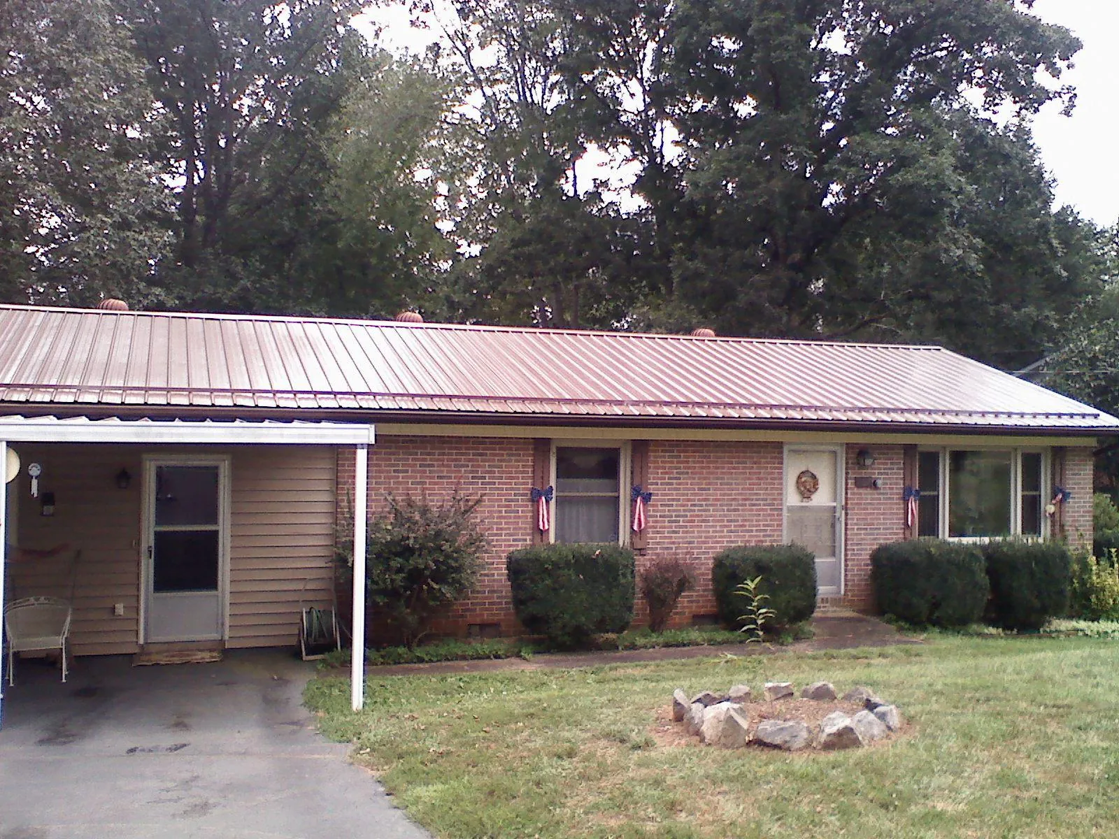 Bronze metal roof and carport on a brick ranch home — Roof Repair work by our crew in Harris